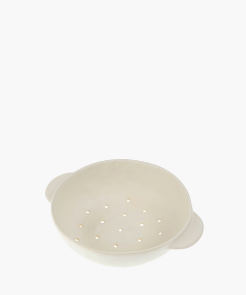 A white ceramic colander features a smooth finish and two handles, with evenly spaced drainage holes, conveying a minimalistic and functional design. | SW Home