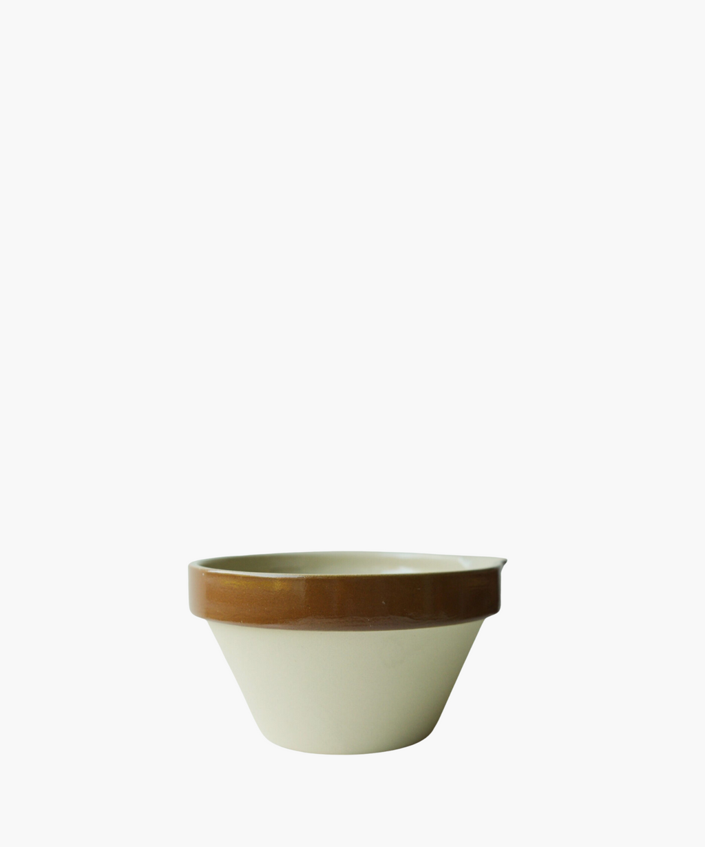 A ceramic bowl with a beige base and a glossy brown rim. The simple and functional design conveys a rustic and practical tone.